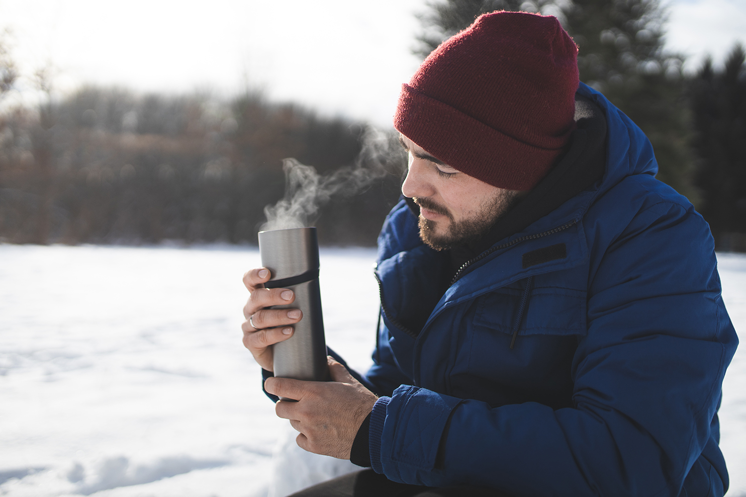 Wandern im Winter – Mann mit Thermoskanne